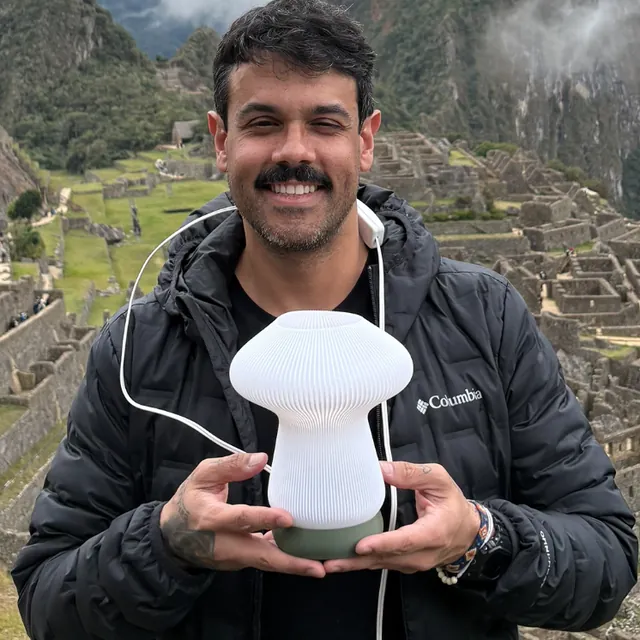 Diego Amado segurando uma luminária impressa em 3D